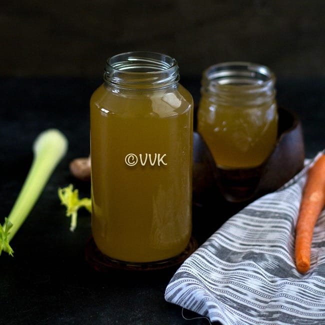 vegetable broth in a big bottle with celery and carrots on the side