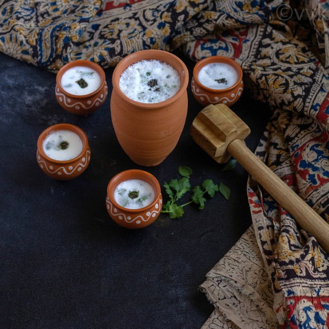 neer mor in clay tumbler and with four small clay tumblers around