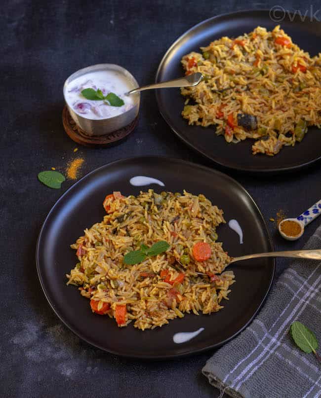 delhi veg biryani in black plates with spoon