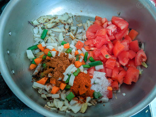 idli biryani adding spices, tomatoes and vegetables
