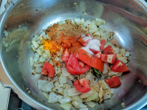 veg biryani adding tomatoes and spices