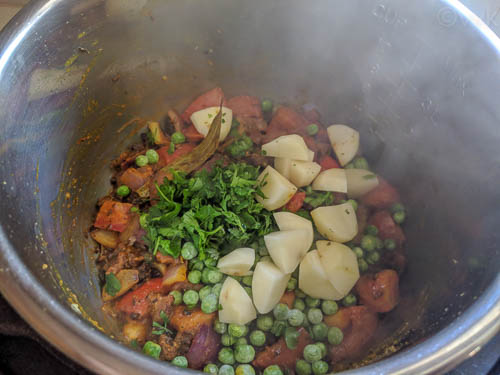 wadi ki biryani adding potatoes peas and cilantro