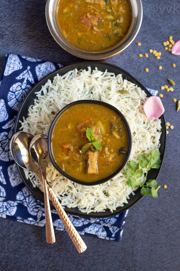 dalcha placed in black bowl on top of rice plate