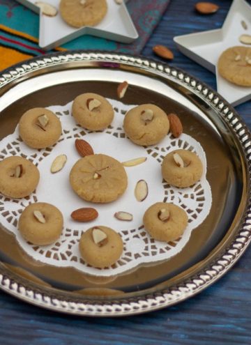 badam peda on a silver plate placed on white paper