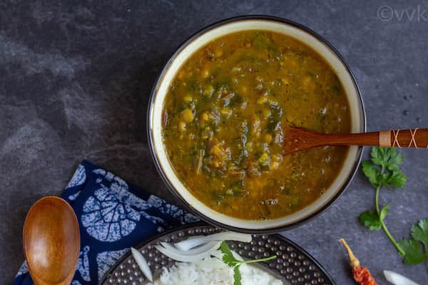 simple beet greens dal in a ceramic bowl with a wooden spoon