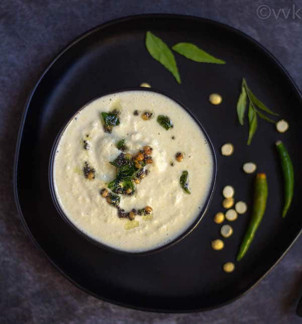 coconut chutney on a black bowl placed on a black plate