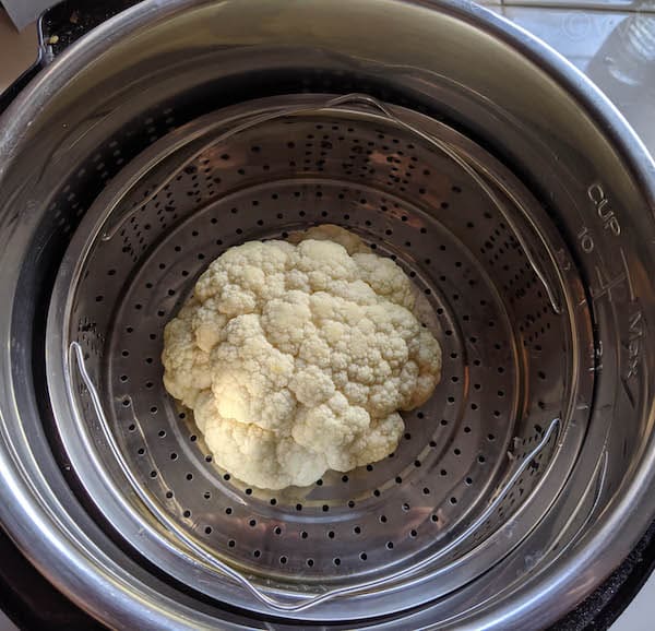 place the steamer basket with cauliflower in the Instant Pot
