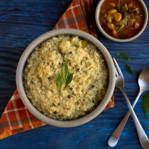 quinoa and millet ven pongal on a clay bowl with gojju on the side