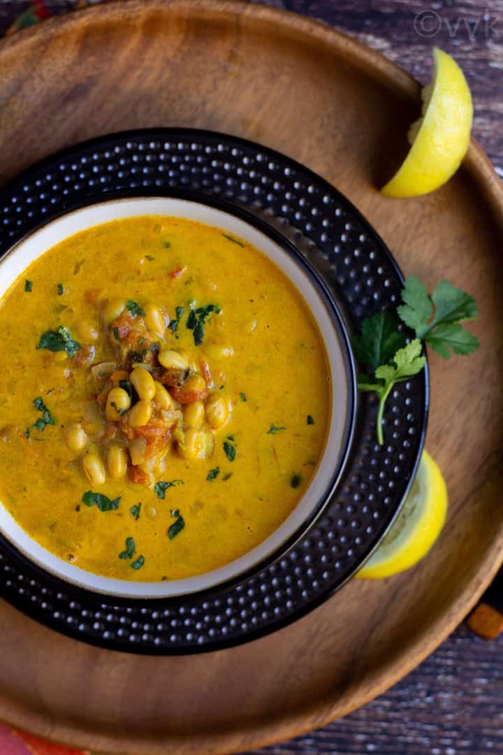 top angle shot of soybean curry with cilantro and lemon wedges on the side