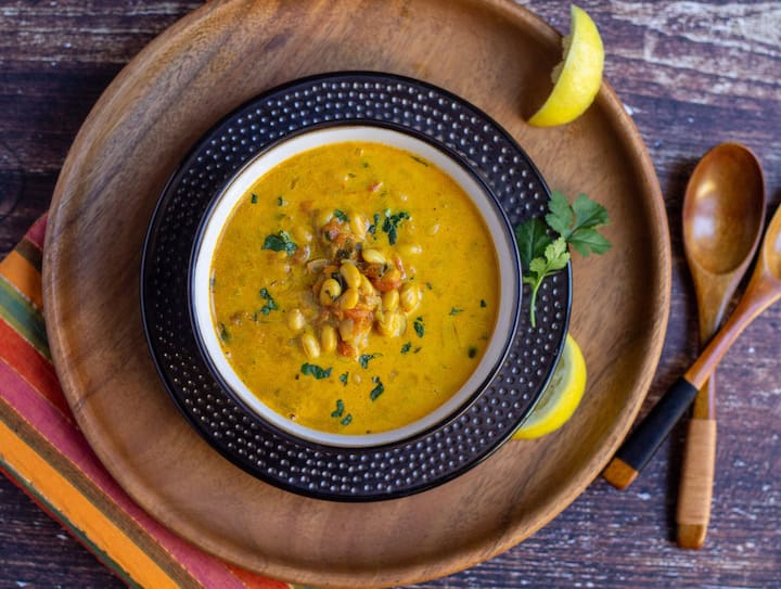 top angle shot of soybean curry placed in a bowl placed on a wooden board