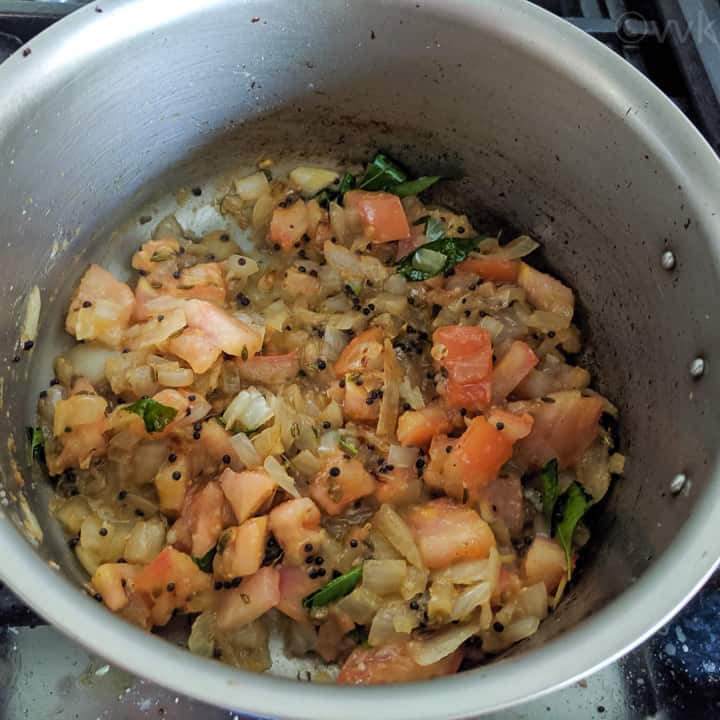 adding tomatoes to the kurma kuzhambu gravy base