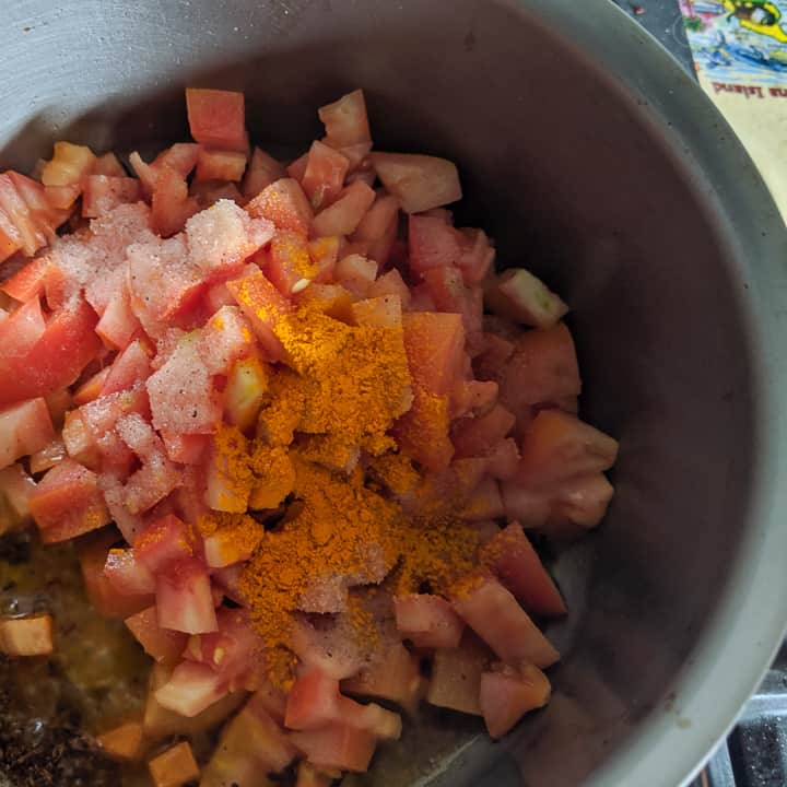 adding tomatoes to bharta