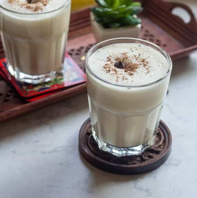 banana milkshake in a glass cup garnished with grated chocolate