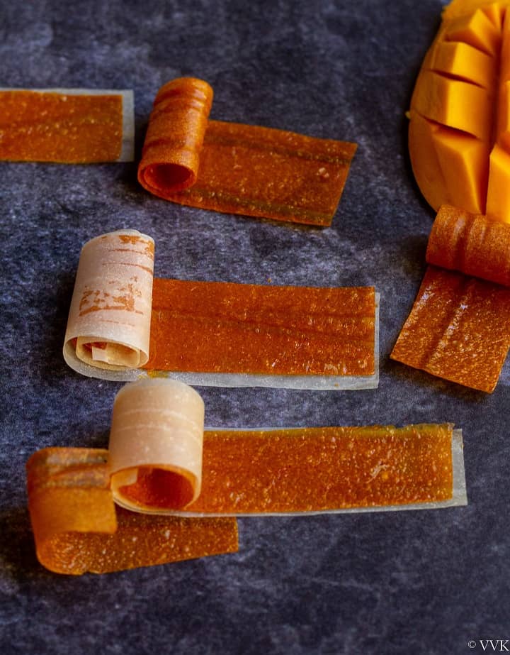 close up shot of mango fruit roll ups with cut mangoon the side