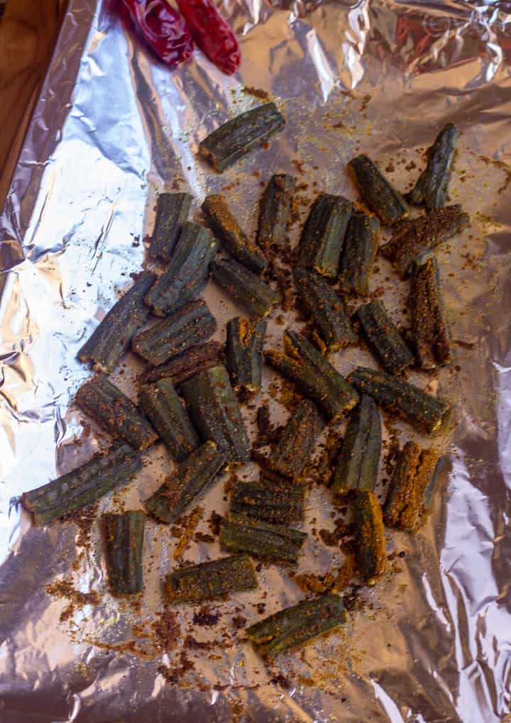 picture of baked okra in the baking tray lined with aluminium foil