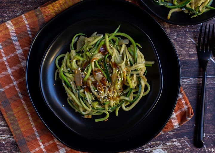 indo chinese zucchini noodles on a black plate