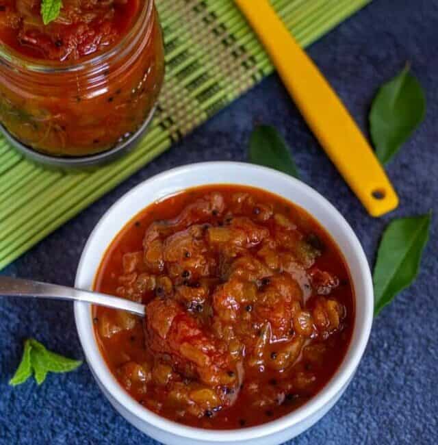 instant pot tomato onion relish in a white bowl with a spoon inside