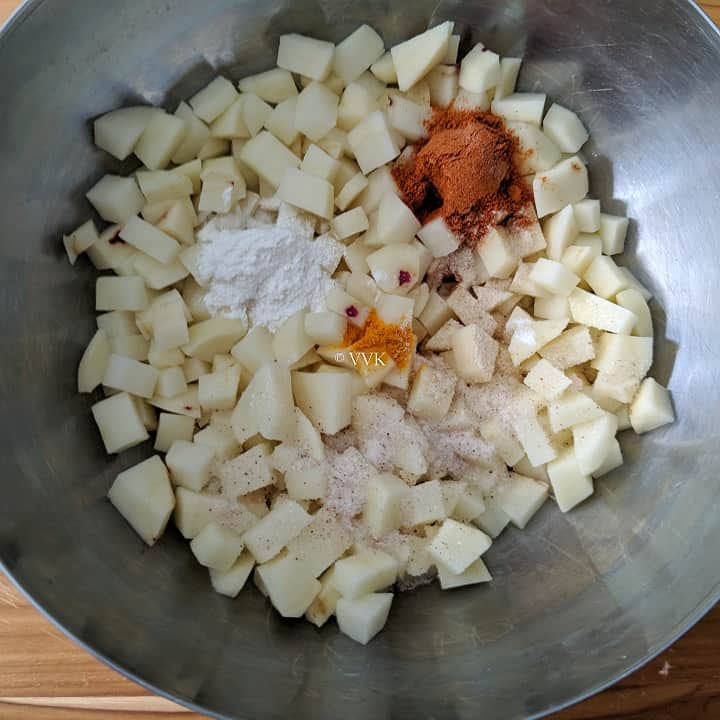 adding spices to the potato curry
