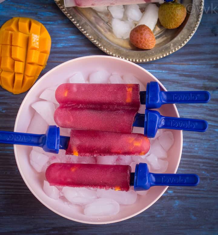 overhead shot of black currant popsicles placed on a pink bowl