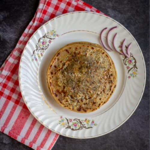 square image of stuffed cheese paratha on a white plate