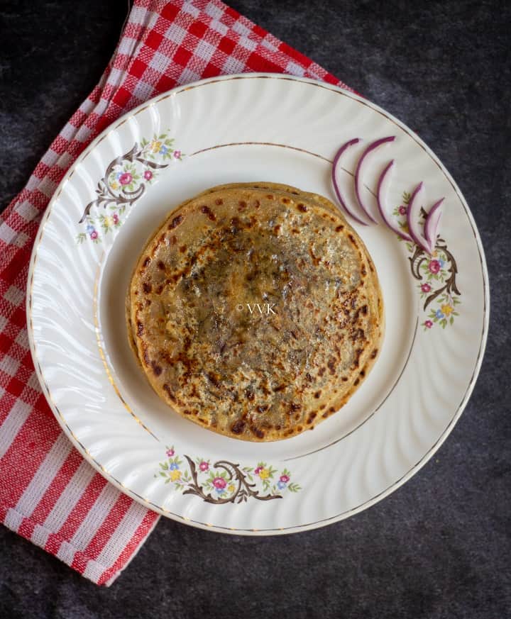 top angle shot of stuffed paratha served on a white plate