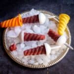 square image of kala khatta popsciles on a plate with ice
