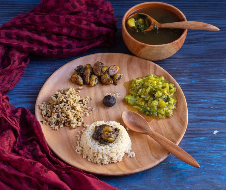 slanting shot of pathiya sapadu with rice, milagu kuzhambu, poondu, kootu and rasam