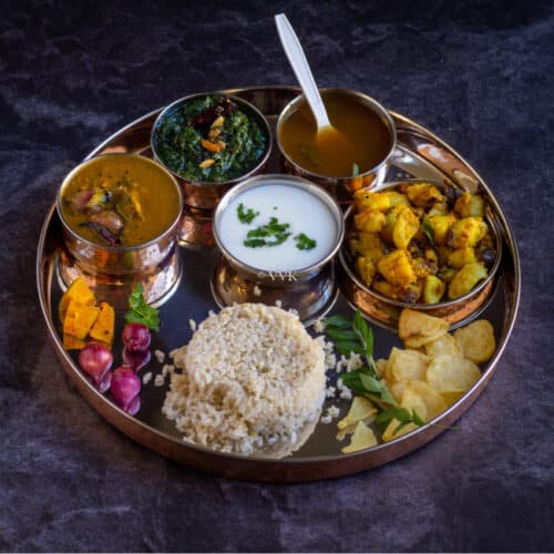 square image of south indian lunch thali with sambar, rasam, potato