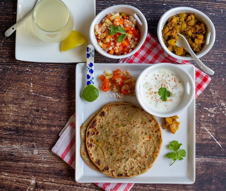 broccoli carrot paratha thali with all the condiments salad, pickle, chutney, and drink