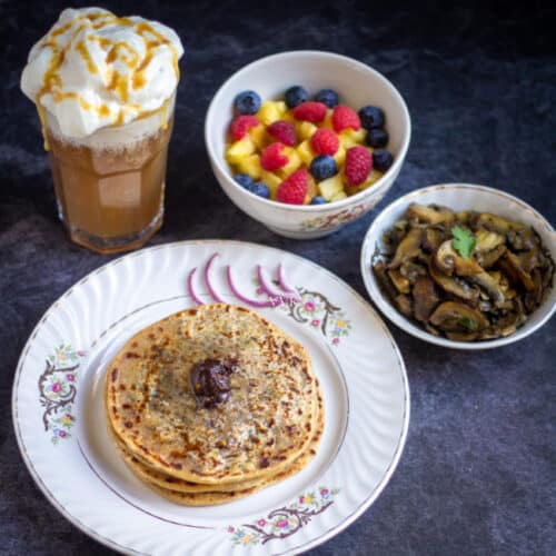 square image of cheese paratha thali with mushrooms, butterbeer and fruit salad