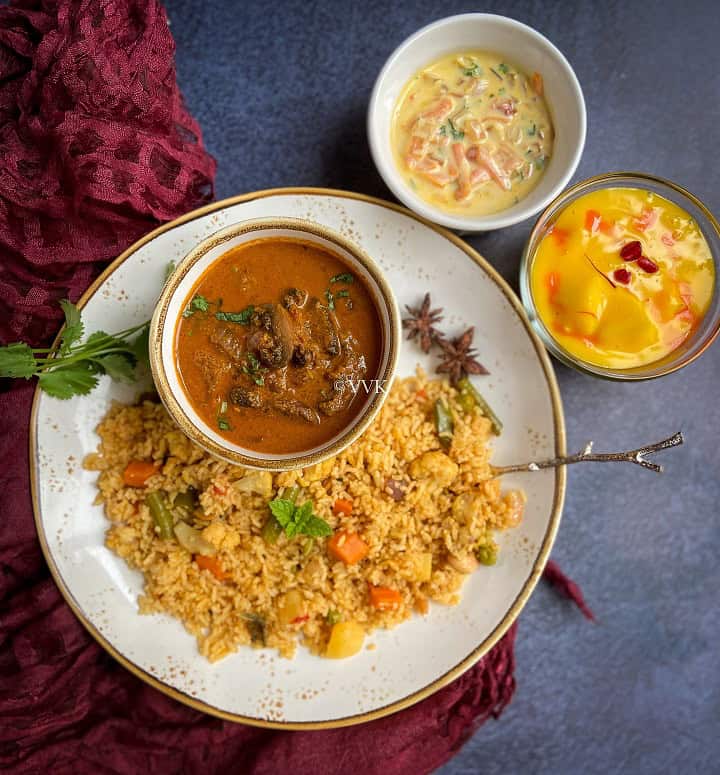 veg biryani served with mushroom gravy and raita with fruit custard as a dessert