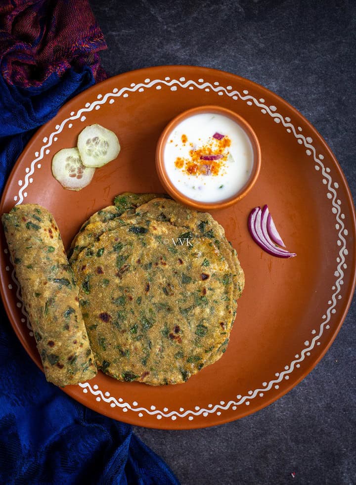 methi paratha in a terracotta with one rolled