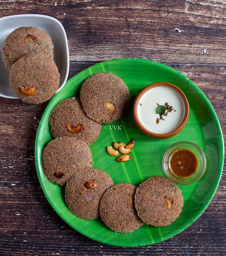 overhead shot of ragi idli served in green plate with chuntey and podi