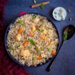 mixed vegetable pulao in a big bowl served with raita