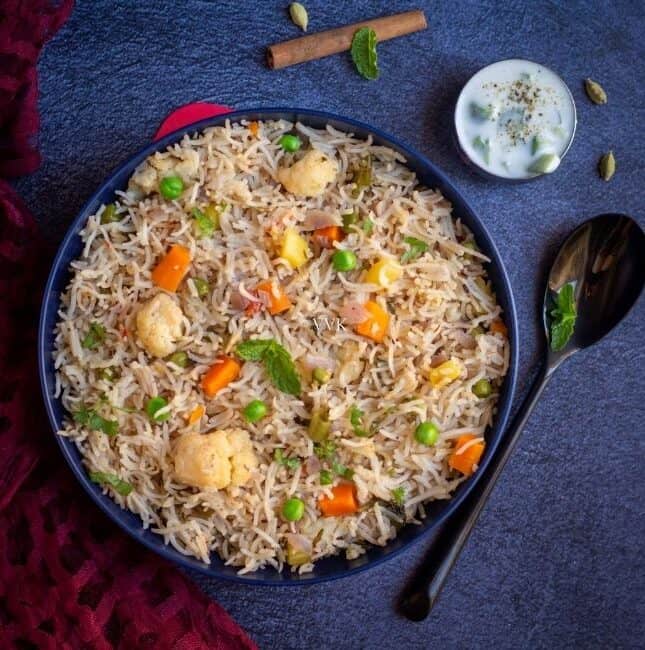 mixed vegetable pulao in a big bowl served with raita