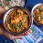 handshot of matar paneer served in a copperware