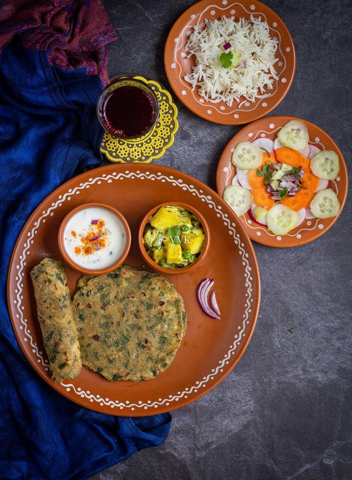 methi paratha thali with rice, paneer curry, salad and iced tea