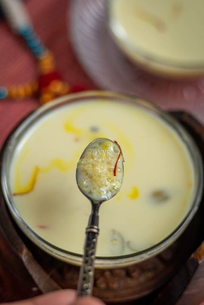 quinoa kheer in a glass bowl with spoonful of kheer