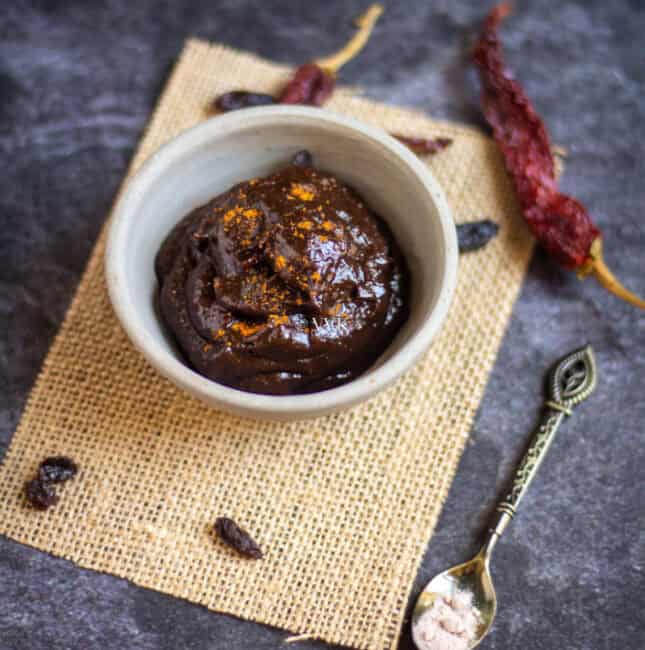 square image of raisin chutney in white ceramic bowl