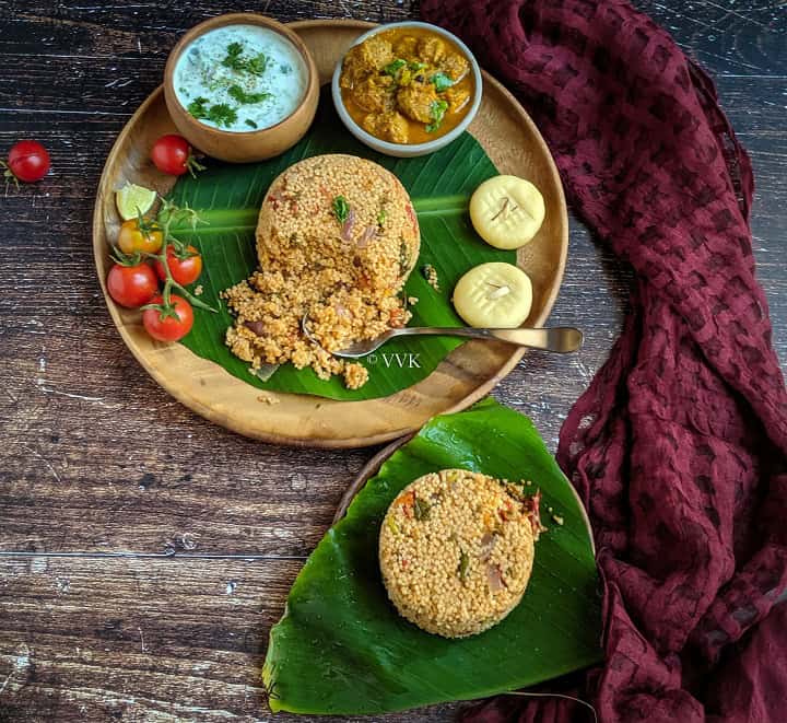 biryani served in a wooden plate lined with banana leaf with raita, gravy and sweet