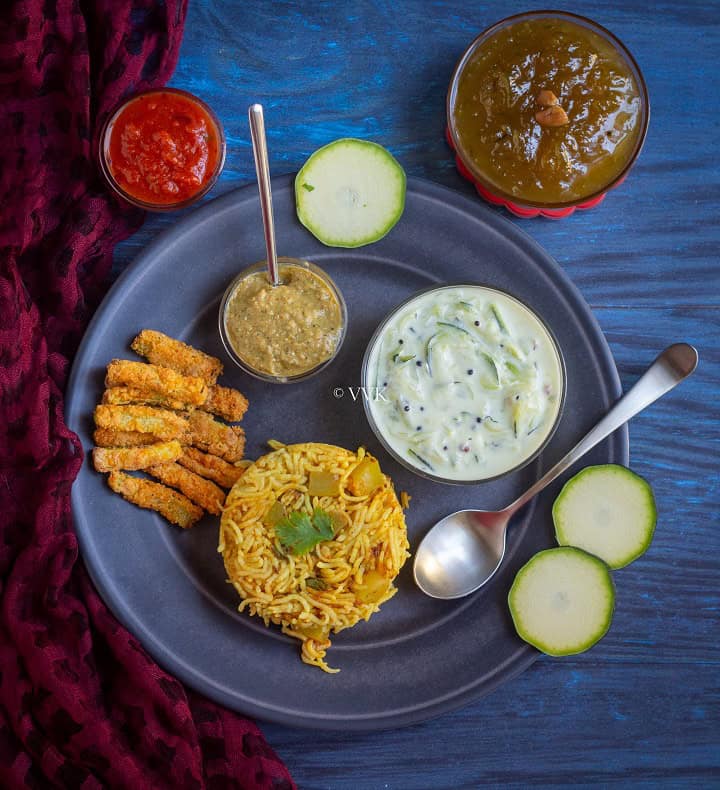 overhead shot of zucchini platter with fries, rice, chutney, halwa and raita