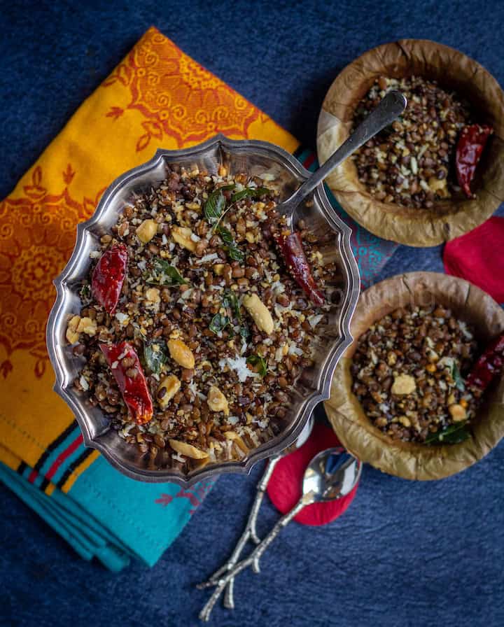 overhead shot of kollu sundal served in silverware and in leaf bowls