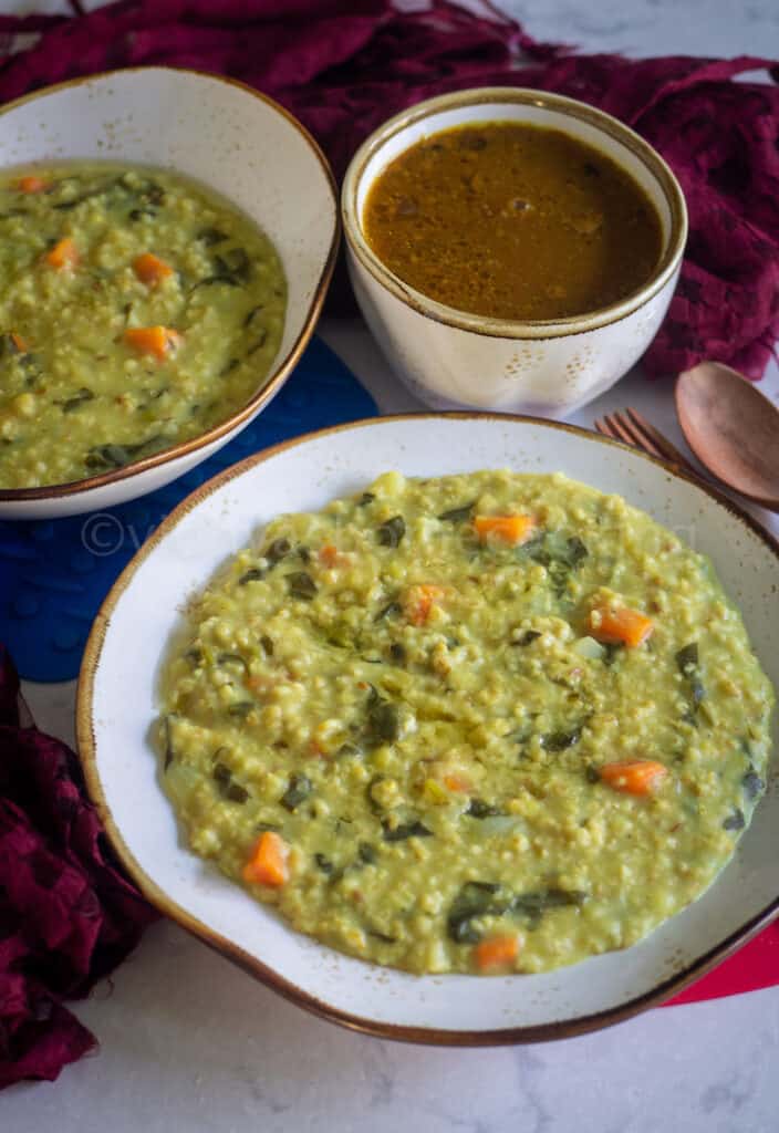 instant pot khichdi served in white serveware with wooden spoons and vathal kuzhambu