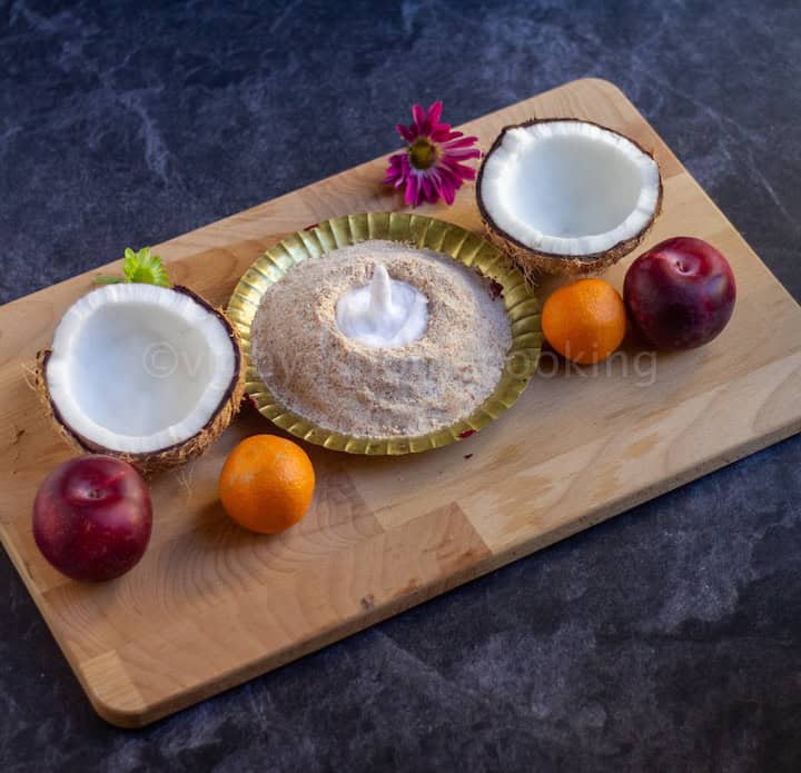  maa vilakku placed on a wooden board with fruits, flowers and coconut