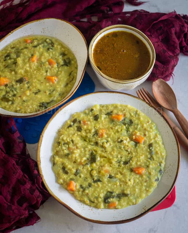 instant pot khichdi served in white serveware with wooden spoons and vathal kuzhambu