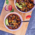 square image of vegetarian chili served in a pink bowl