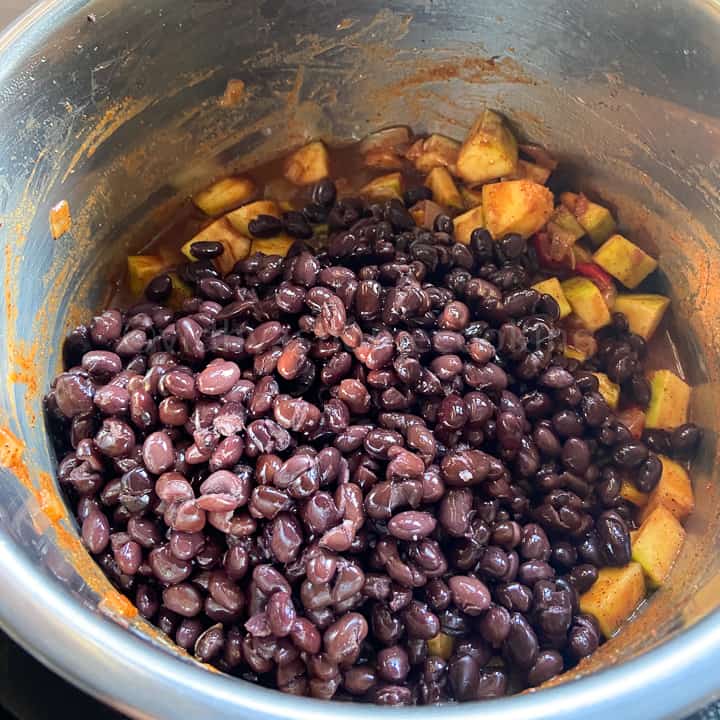 adding the beans and cooking chili
