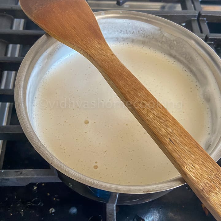 placing a wooden spatula on top of the milk vessel