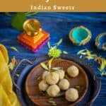 thinai laddu served on a wooden plate with flowers and nuts drizzled with lamps on the side