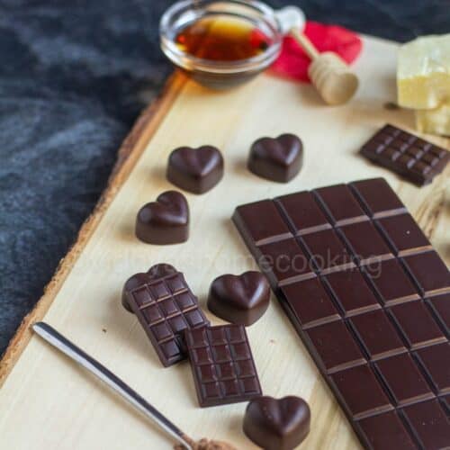 homemade dark chocolate bar and heart shaped ones placed on wooden board